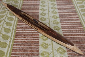fq2017bwalfbempl31: black walnut featherwood top/bottom, bird's eye maple center. 5.0 oz., 19″L, 1 1/2″W, 3/4″H, 6″ tip to nearest cavity end. Fits 6" quills.  This is a very long specialty shuttle, $140 plus shipping.