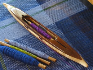 QShuttle9: Black walnut top/bottom, bird's eye maple center. 3.0oz. 13 3/8"L, 1 5/16"W, 3/4" H, 4" cavity end to tip. Fits 4" quills.