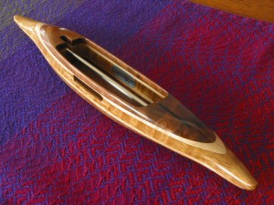 StdB4Shuttle35: Black walnut featherwood top/bottom, curly maple 2nd layers, curly white oak center. 4.2oz., 12 1/2"L, 1 3/4"W, 1"H, 3  7/8" cavity end to tip. Fits 4" bobbins