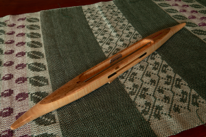 s2018Qbemapltmapl1: Bird's eye maple top/bottom, tiger maple center. Lignum Vitae yarn slot inserts. 4.1oz., 16 1/2″L, 1 1/2″W, 3/4 ″H, 4  3/4″ tip to nearest cavity end. Fits 6″ quills.