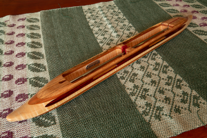 s2018dblmesqtmpl6:  mesquite top/bottom, cherry 2nd layers, tiger maple center. Cocobolo yarn slot and pink ivory center divide  inlays. 7.0 oz., 18″L, 1 3/4″W, 1 1/16″H, 3 3/4″ tip to nearest cavity end. Fits two 4″ bobbins.