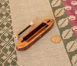 Brocade4 top view 5 1/4" L x 1" W x 13/16" H.  0.9 oz. Ash burl top/bottom and black walnut featherwood center. Includes 1 carbonfiber bobbin. Ebony fittings over rod slots; stainless steel rod and yarn hole fitting.