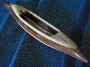 s2015bemaple6: bird's eye maple top/bottom, quartersawn oak 2nd layers, black walnut featherwood center. 5 oz., 12 1/2"L, 1 3/4"W, 1 3/16"H, 4" cavity end to tip. Fits 4" bobbins.